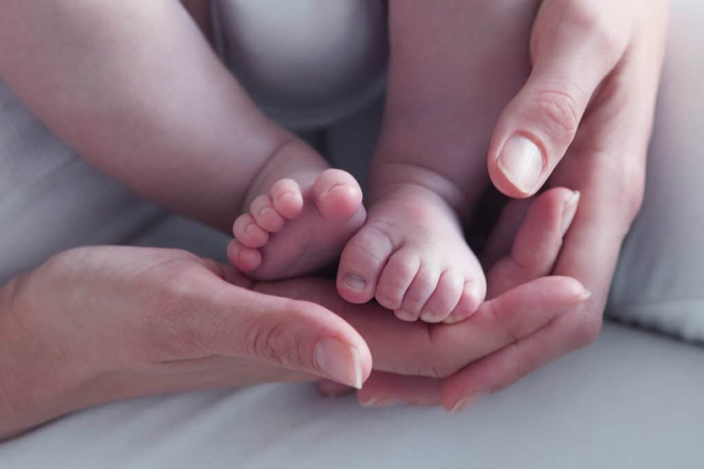 Closeup of mother holding baby boy's feet